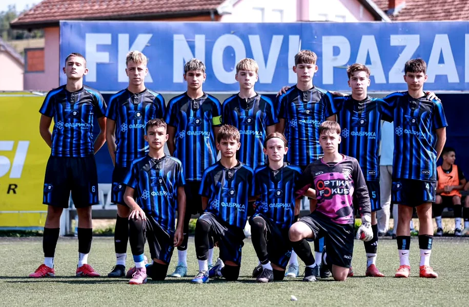 Zajednička fotografija mladih fudbalera u crno-plavim dresovima ispred natpisa FK Novi Pazar